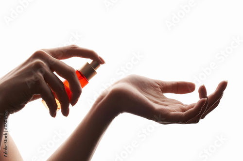 woman applying perfume on her wrist
