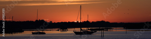 Silhouette of Sailboats at Sunrise