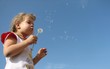 Girl blowing a seedy dandelion