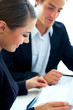 Smart couple going through documents sitting in the office
