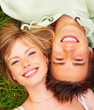 A happy couple lying on grass