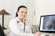 Portrait of female doctor sitting at the table with x-ray scan o Portrait of female doctor sitting at the table with x-ray scan o