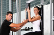 woman in the fitness gim working out with personal trainer
