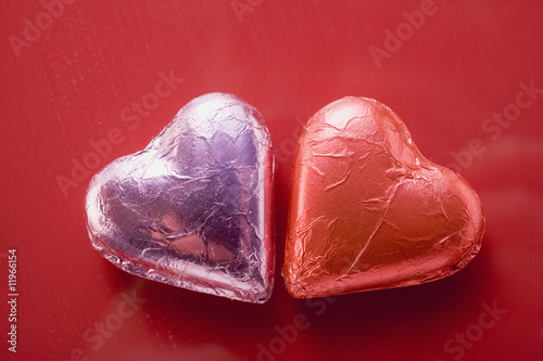 Photo: two heart-shaped chocolates in foil two heart-shaped chocolates in foil