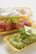 guacamole, tomato salsa and sour cream in taco shells