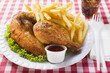 half a roast chicken with chips on paper plate