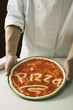 Foto: pizza base spread with tomato sauce, with the word pizza pizza base spread with tomato sauce, with the word pizza