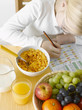 girl with exercise book in front of healthy breakfast