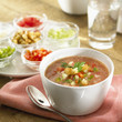 gazpacho in soup bowl, surrounded by ingredients