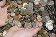 Hands in the pile of different white, red and yellow coins