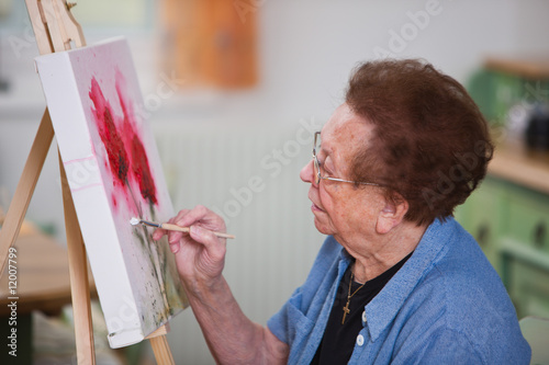Photo: Aktive Seniorin malt in Freizeit ein Bild Aktive Seniorin malt in Freizeit ein Bild