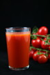 Tomato juice in glass and tomatos