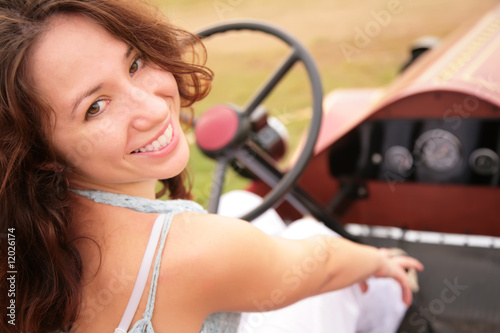 Photo: Woman sits having turned back in salon of the ancient car Woman sits having turned back in salon of the ancient car