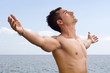 Modelo masculino con los brazos abiertos hacia el cielo Modelo masculino con los brazos abiertos hacia el cielo