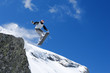 Male snowboarder jumping of a hill