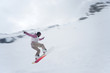 Girl with snowboard jumping of a hill