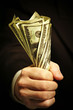 man's hand holds dollars