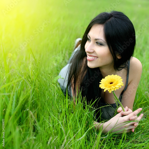 Photo: beautiful young woman relaxing in the grass beautiful young woman relaxing in the grass