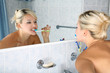 girl in bathroom with toothbrush and mirror