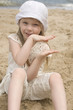 The girl holds hands sitting on the beach