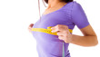 Girl measures her breast with a measuring tape on white