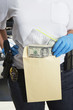 Police Officer Putting Money in Evidence Envelope