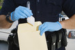 Police Officer Putting Cocaine in Evidence Envelope