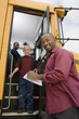 Teacher Unloading Elementary Students from School Bus