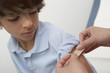 Nurse placing bandage on boy's arm,close up