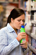 Frau in Drogerimarkt kauft Shampoo