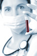 A female health professional looking at a blood sample