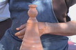 Potters hands creating a clay vase on the turning wheel
