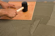 Hammering the floor tile in place