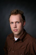 Photo: serious looking young man in a brown shirt serious looking young man in a brown shirt