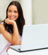 Closeup portrait of young female holding a card and using laptop
