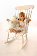 Little Girl in a Big White Rocking Chair with her Teddy Bear