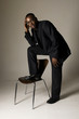 black male in suit with foot on a chair black male in suit with foot on a chair