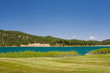 An aqua lake near a golf hole