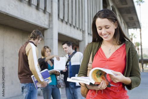 Foto: Female university student holding book, outdoors Female university student holding book, outdoors