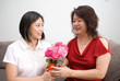Asian mum receiving bouquet of red and pink roses