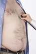 Doctor hand with stethoscope on overweight man's heart,, mid section