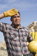 Construction worker wiping his forehead with his hand