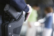 Foto: Close up of a female police woman's gun in holster. Close up of a female police woman's gun in holster.