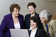 Photo: View of smiling business women looking at a laptop. View of smiling business women looking at a laptop.