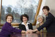 Photo: Portrait of smiling business women sitting by a table. Portrait of smiling business women sitting by a table.