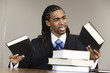 Photo: A confused young business man holding books in an office. A confused young business man holding books in an office.
