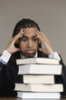 Photo: A tensed young business man looking at books in an office. A tensed young business man looking at books in an office.