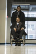 Photo: A businessman helping his colleague in a wheelchair. A businessman helping his colleague in a wheelchair.