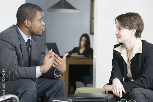 Photo: Business colleagues conversing in an office. Business colleagues conversing in an office.