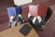 Foto: Business people covering their faces with files. Business people covering their faces with files.